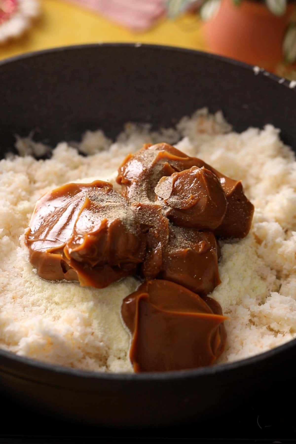 Milk powder and dulce del leched is added to coconut mixture.