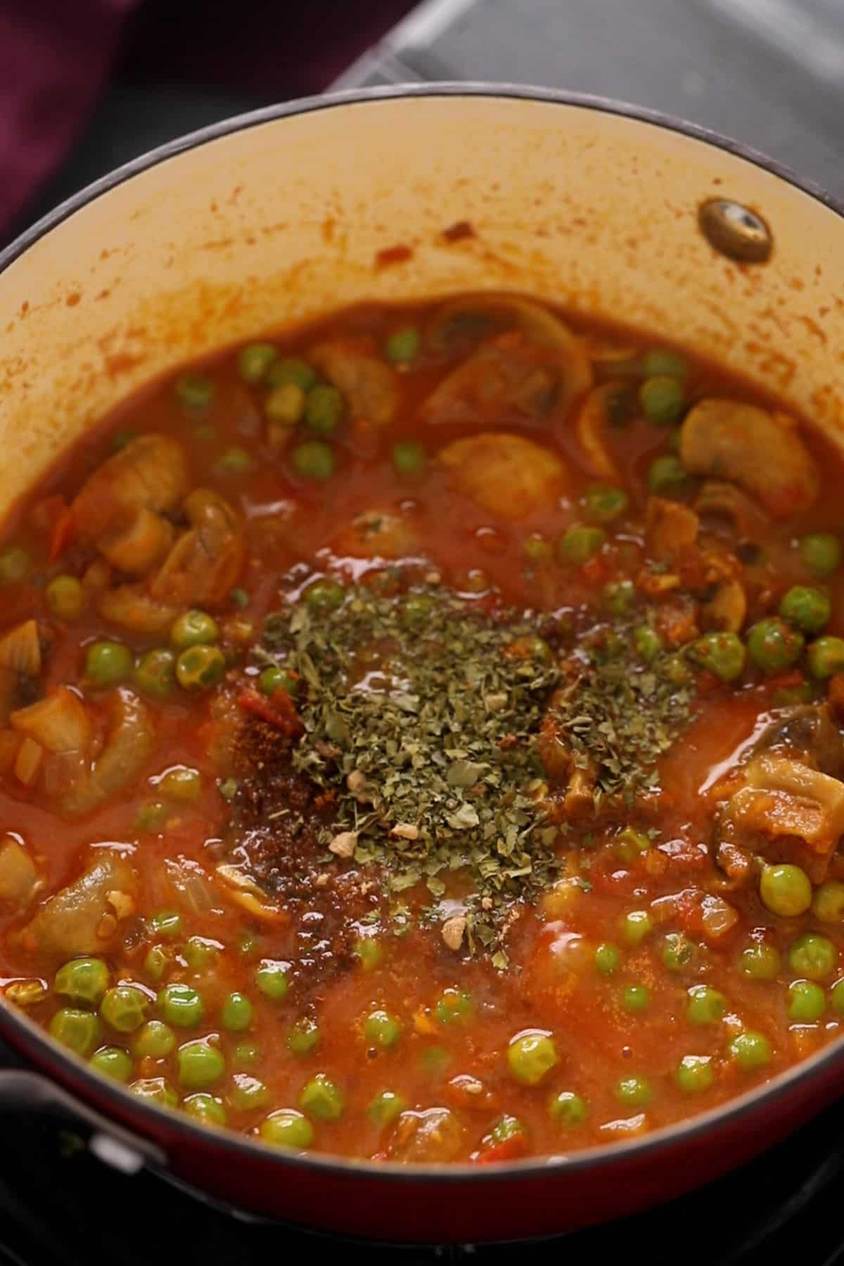 Finishing spices are added to the mushroom matar sabzi.