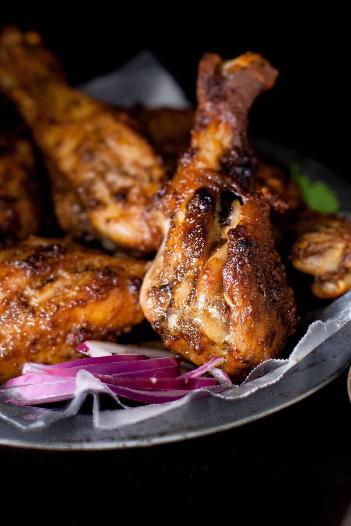 Closeup of tandoori chicken drumsticks after baking.
