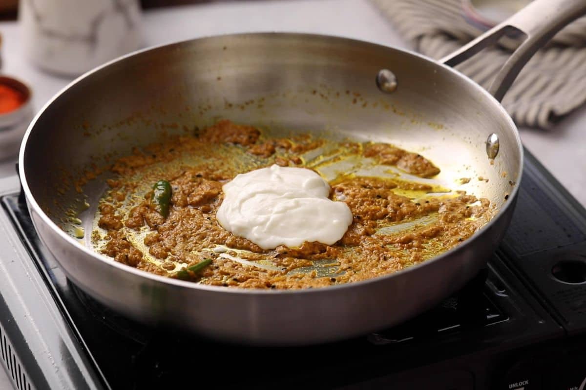 Yogurt is added to mustard masala. 