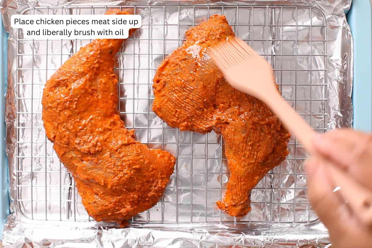 Marinated chicken is placed on a wire rack and oil is brushed.