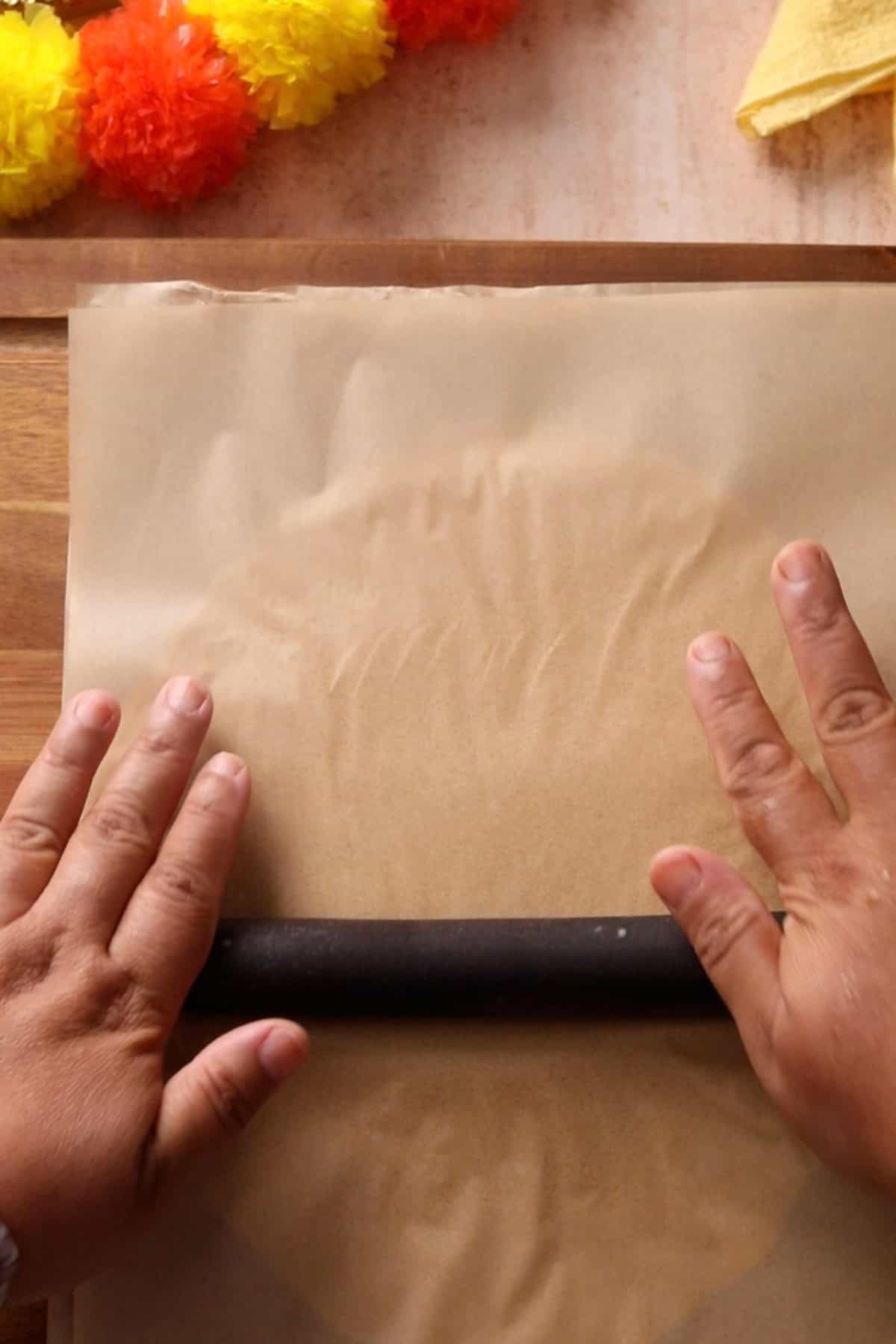 Kaju katli dough is rolled using a rolling pin.