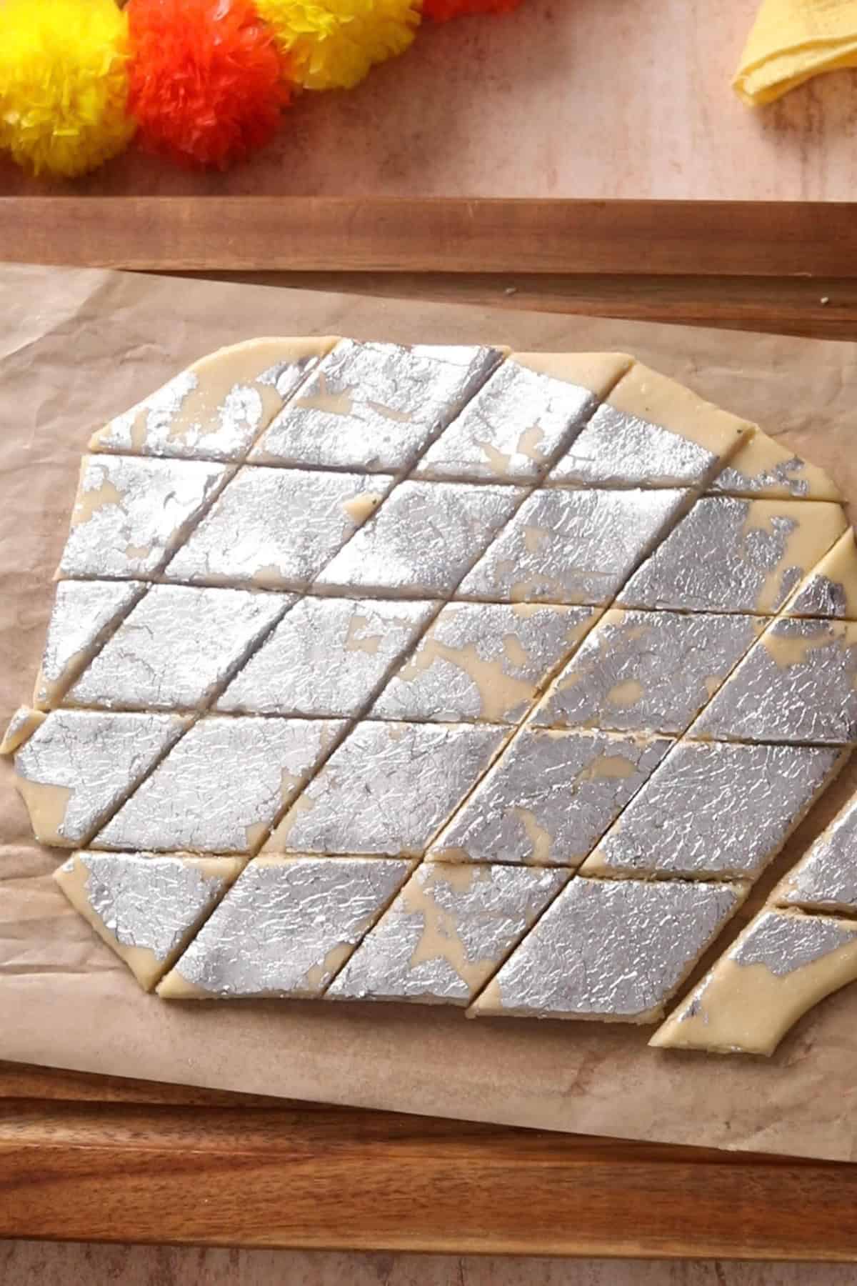 Kaju katli dough is cut into diamond shape.