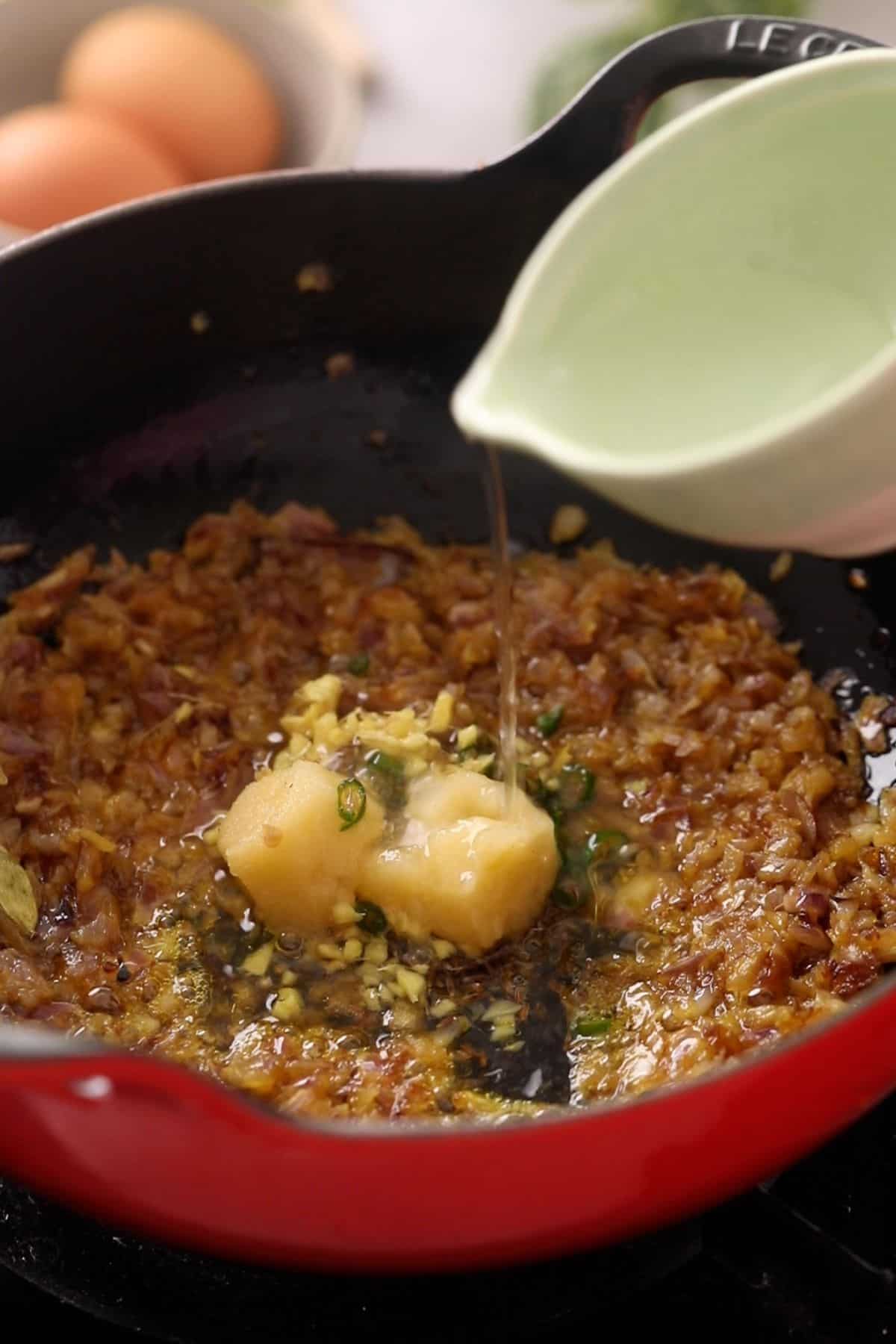 Ginger, garlic and green chillies are added with water to onions.