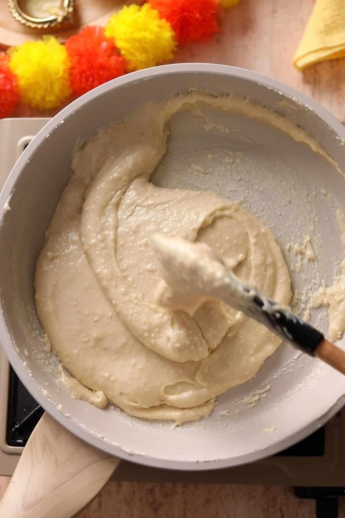 Cashew mixture is being cooked on low flame.