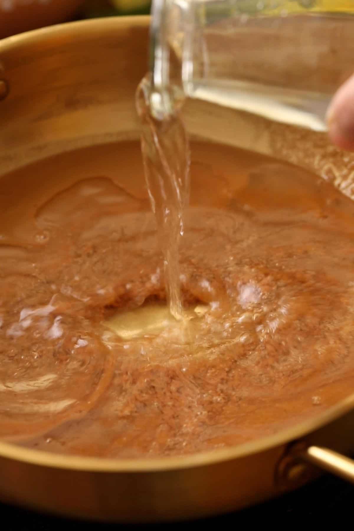 Water is being added to the flour and sugar mixture.