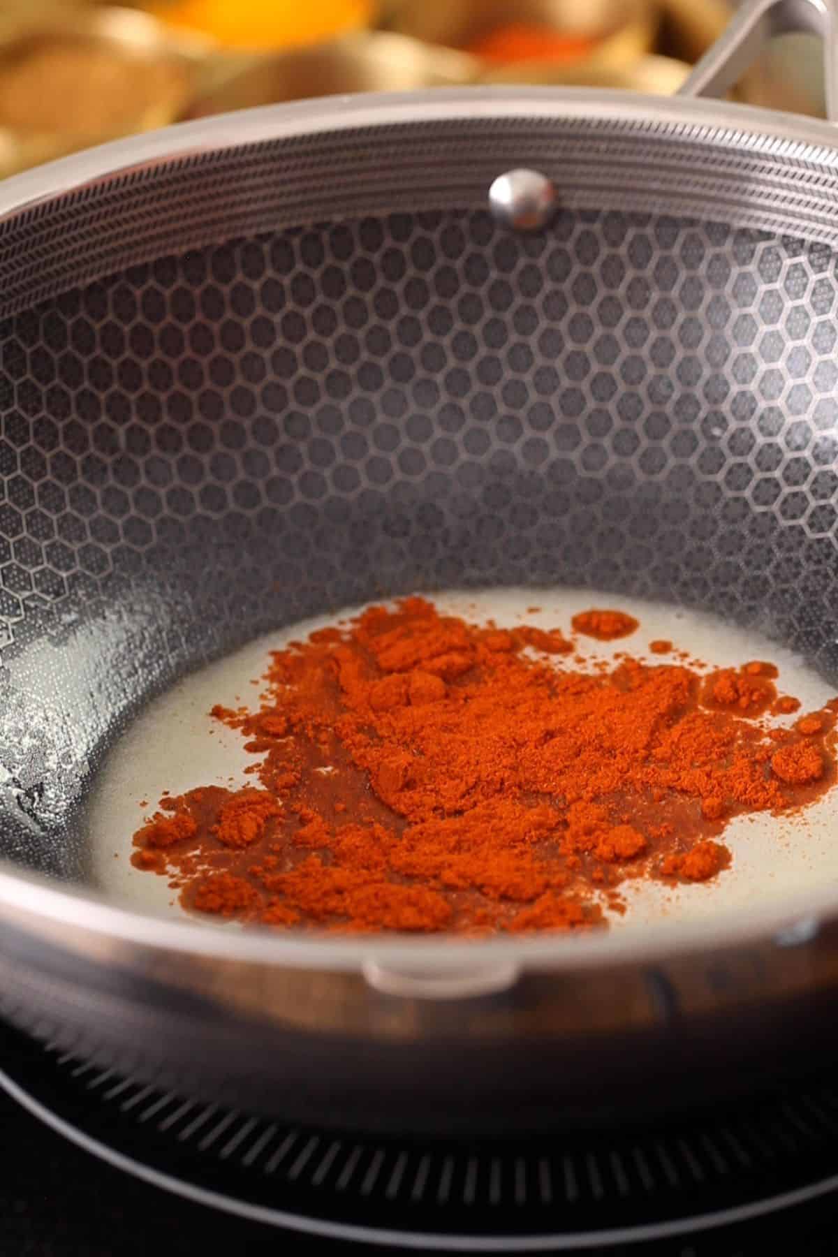 Adding kashmiri red chilli powder to hot butter.