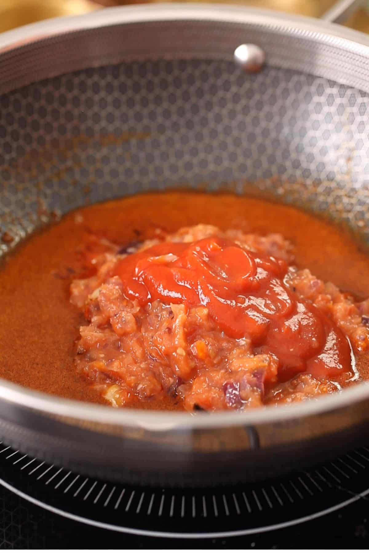 Adding crushed onion tomato paste, tomato sauce to the butter.