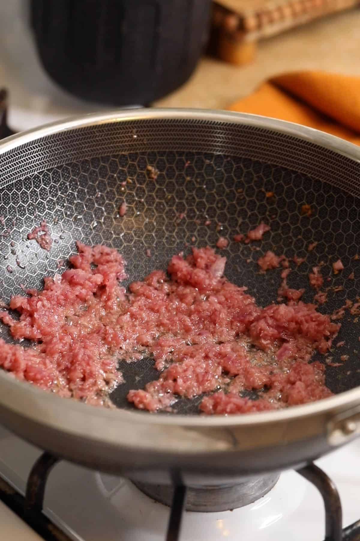 Onions are cooked until light brown.