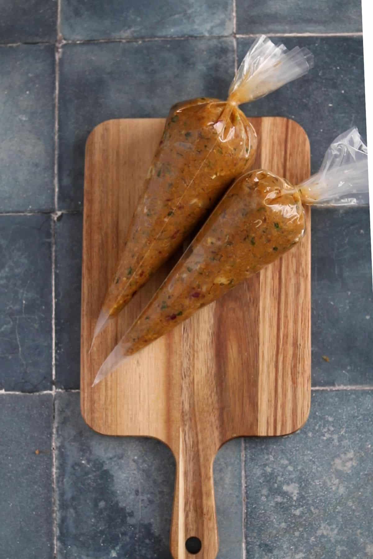 Seekh kebab mixture is added to piping bags. 