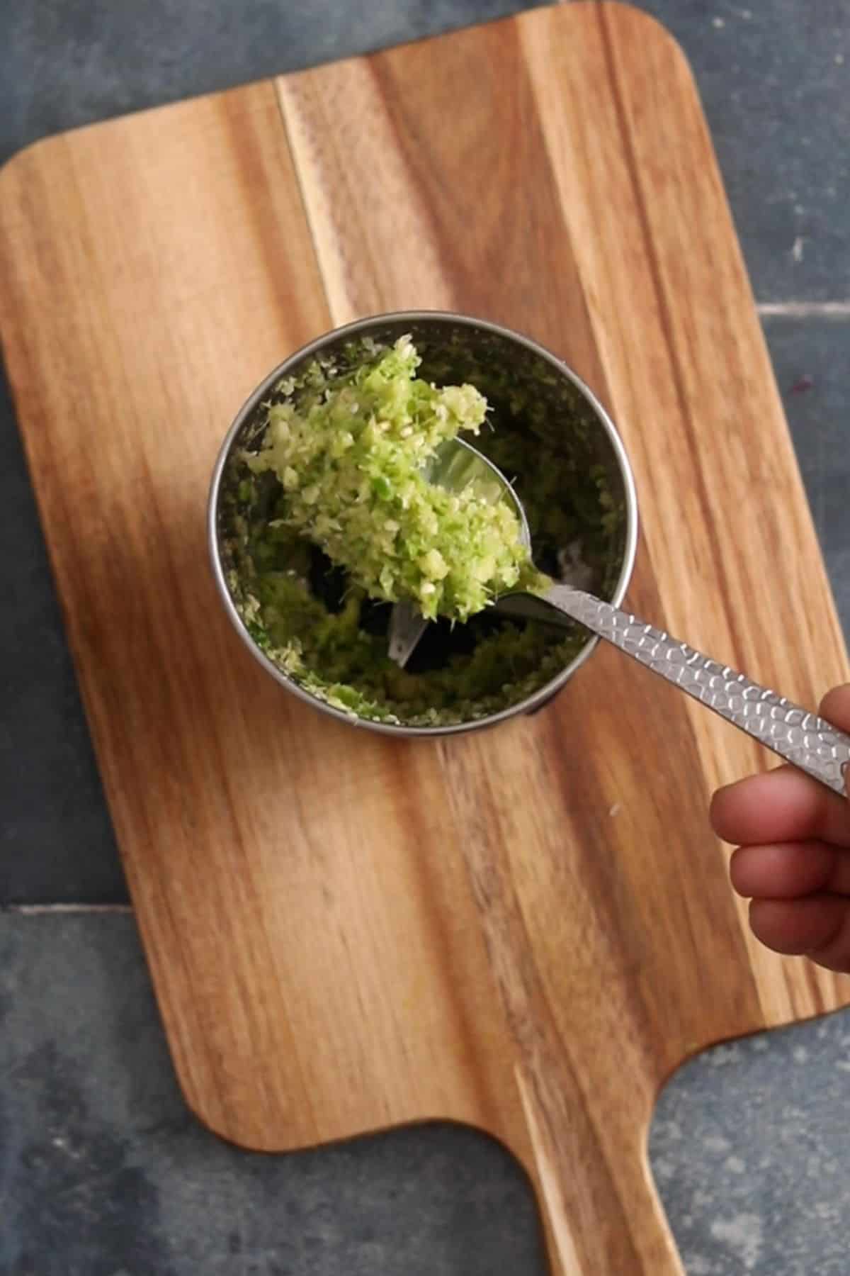 Ground ginger, garlic, cilantro stems and green chilli paste in a spoon over blender jar. 
