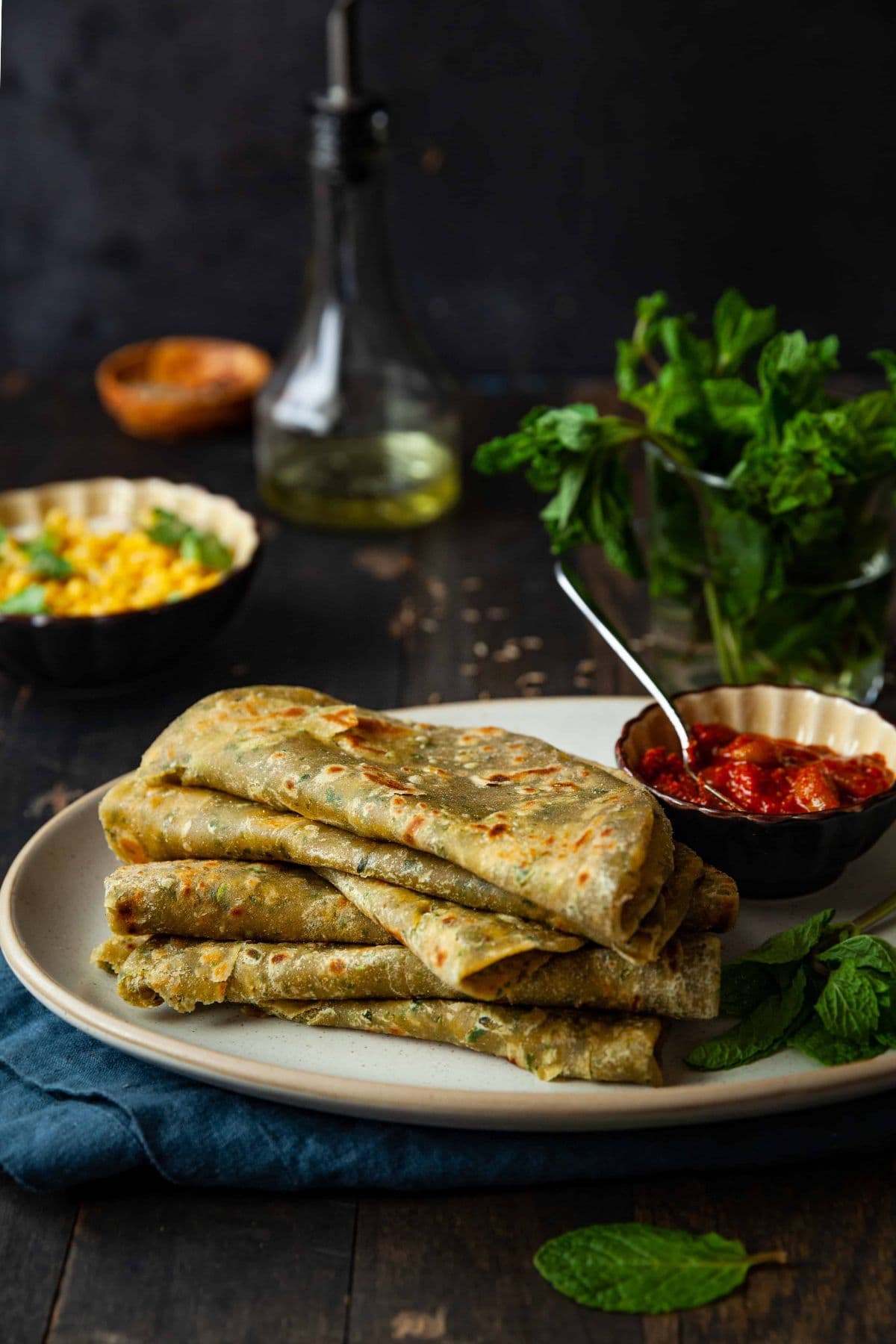 Side view of mint paratha folded and stacked on top of each other.