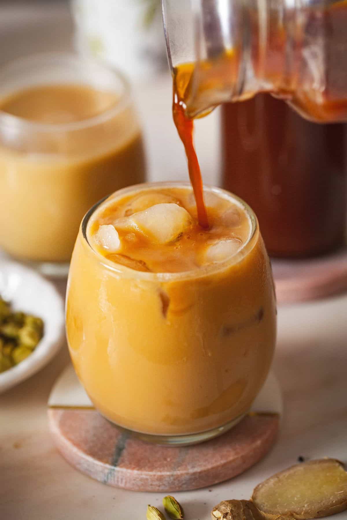 Homemade masala chai concentrate is poured to make chai latter.