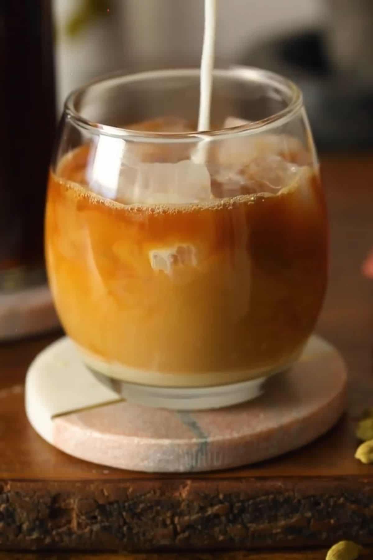 Milk is poured to make ice chai latte.