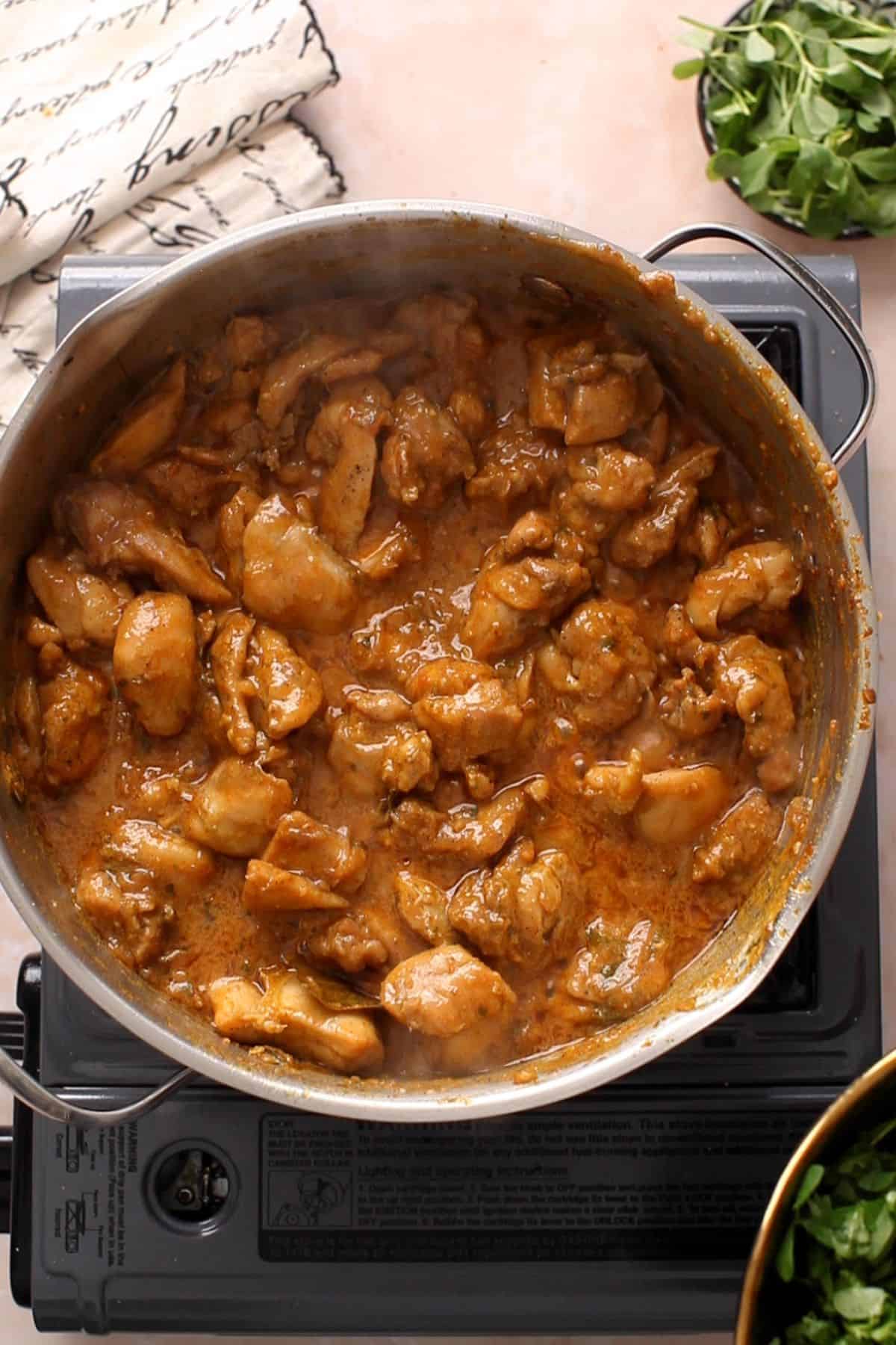 Chicken is cooked with yogurt until oil is seperating.