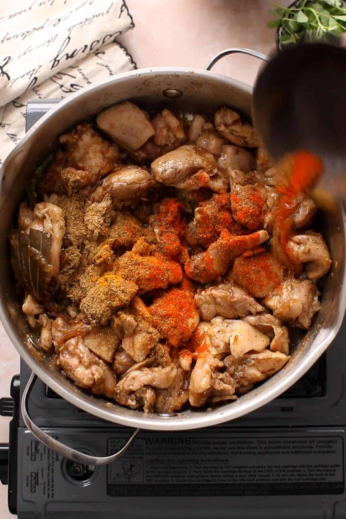 Adding powdered spices to the chicken.