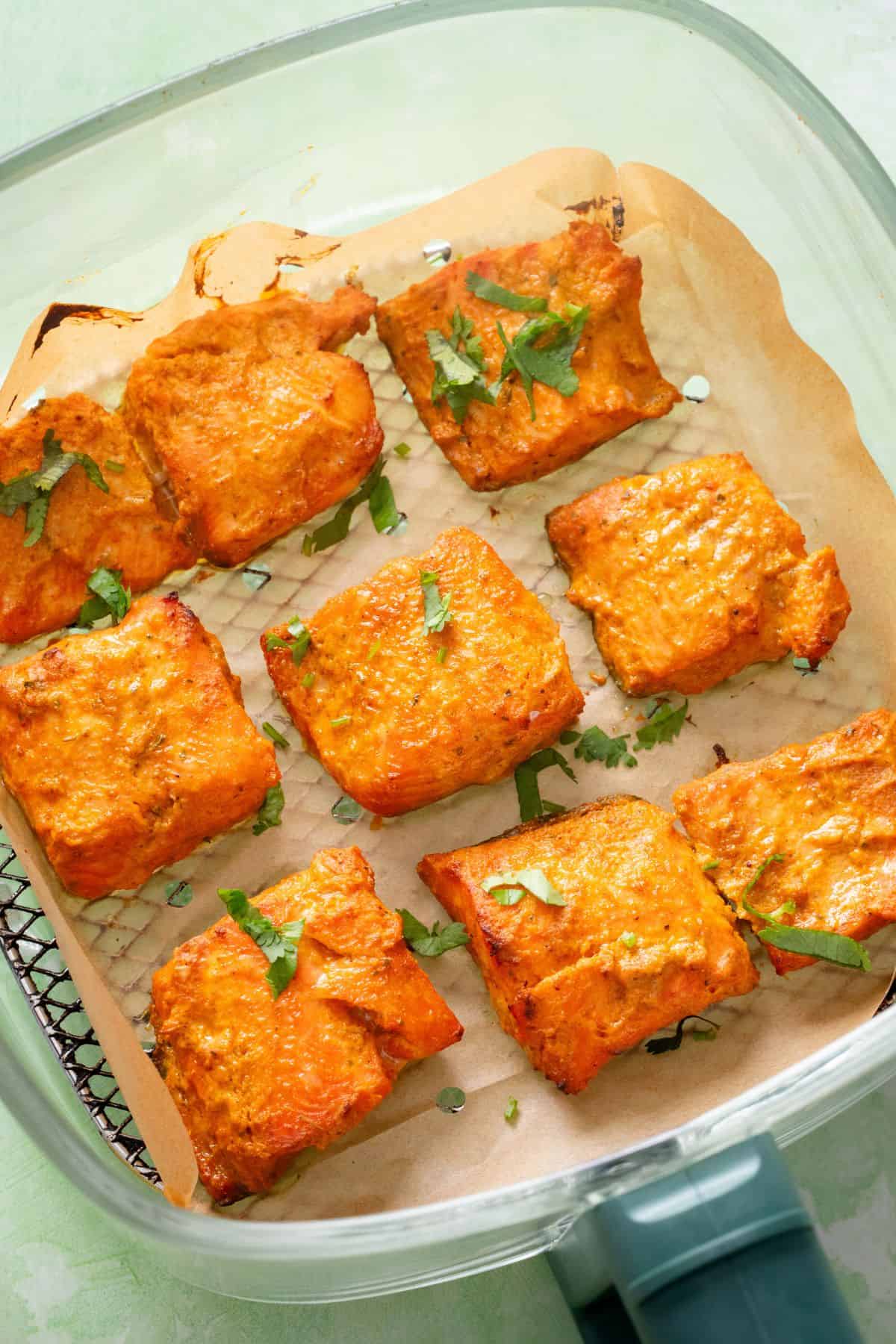 Fish tikka in a glass air fryer basket.