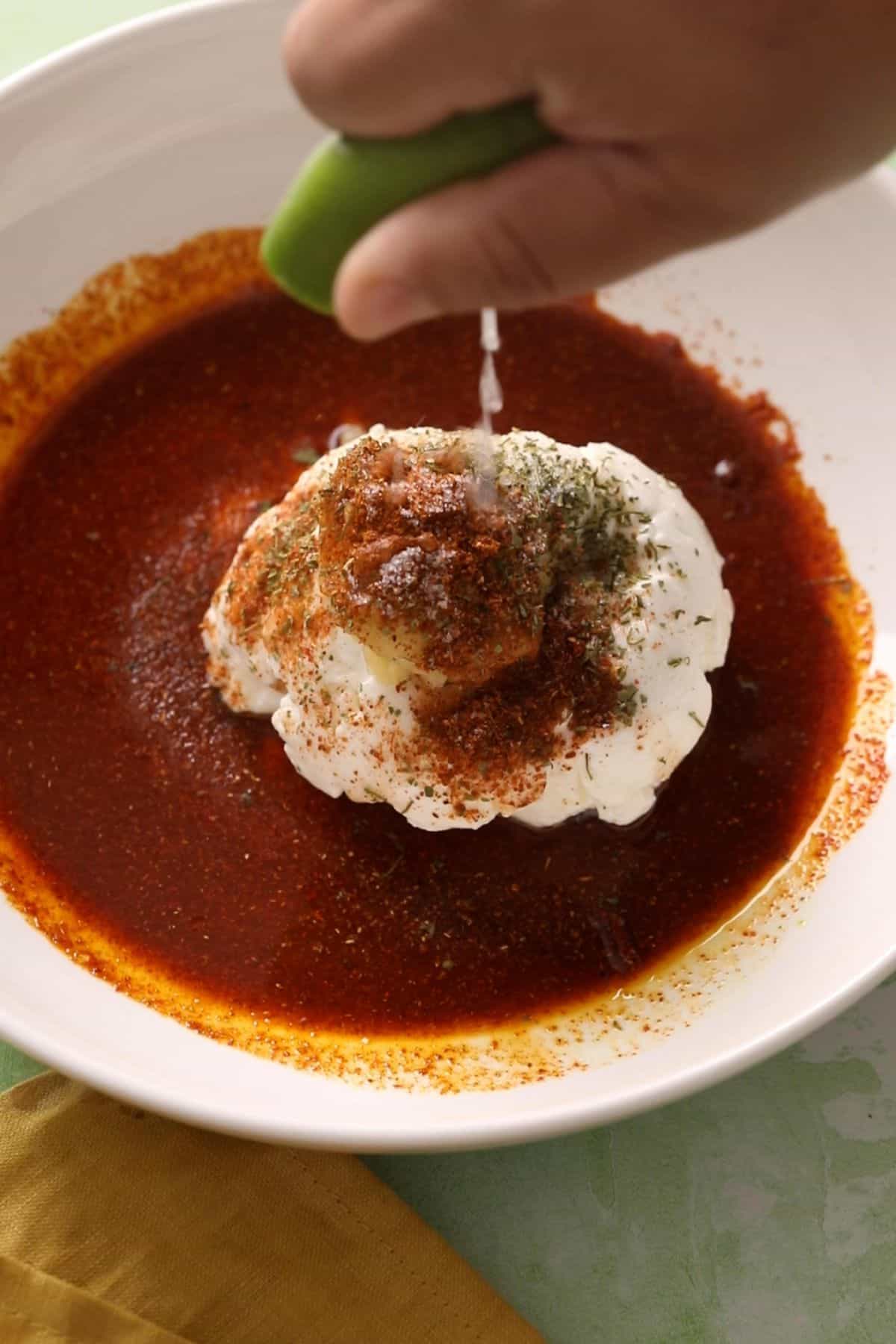 Tandoori marinade ingredients are added to a large white bowl.