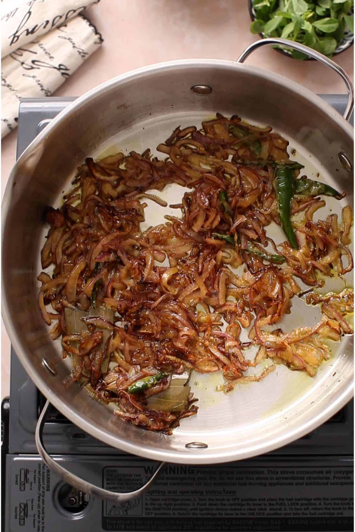 Browned onions in a wide steel pot.