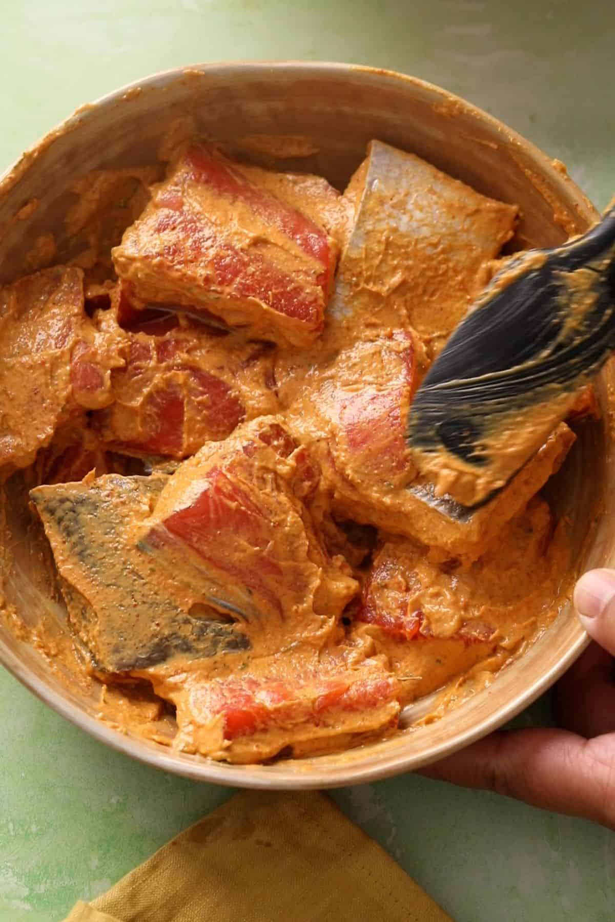 Skin on salmon pieces are coated in the tandoori marinade.