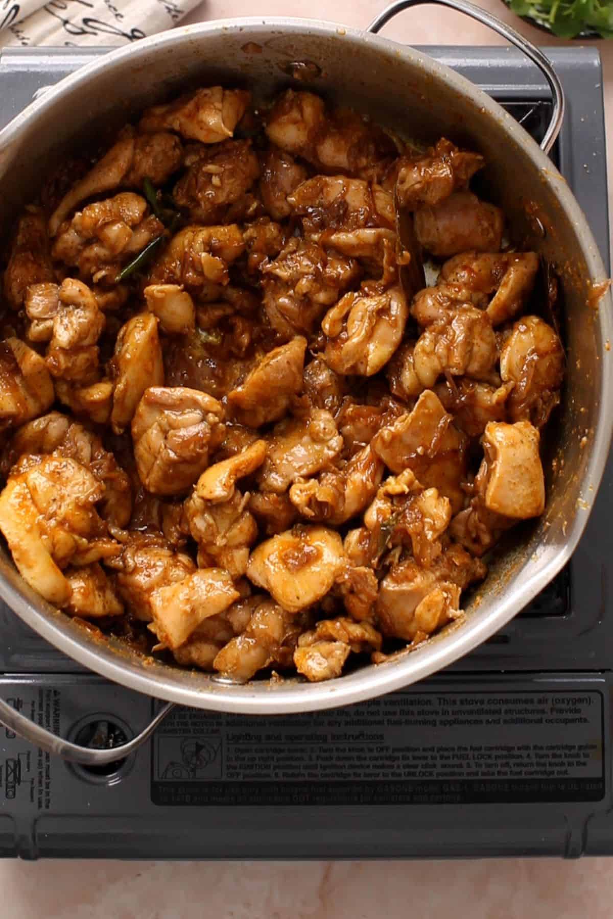 Chicken is fried with the ground spices.