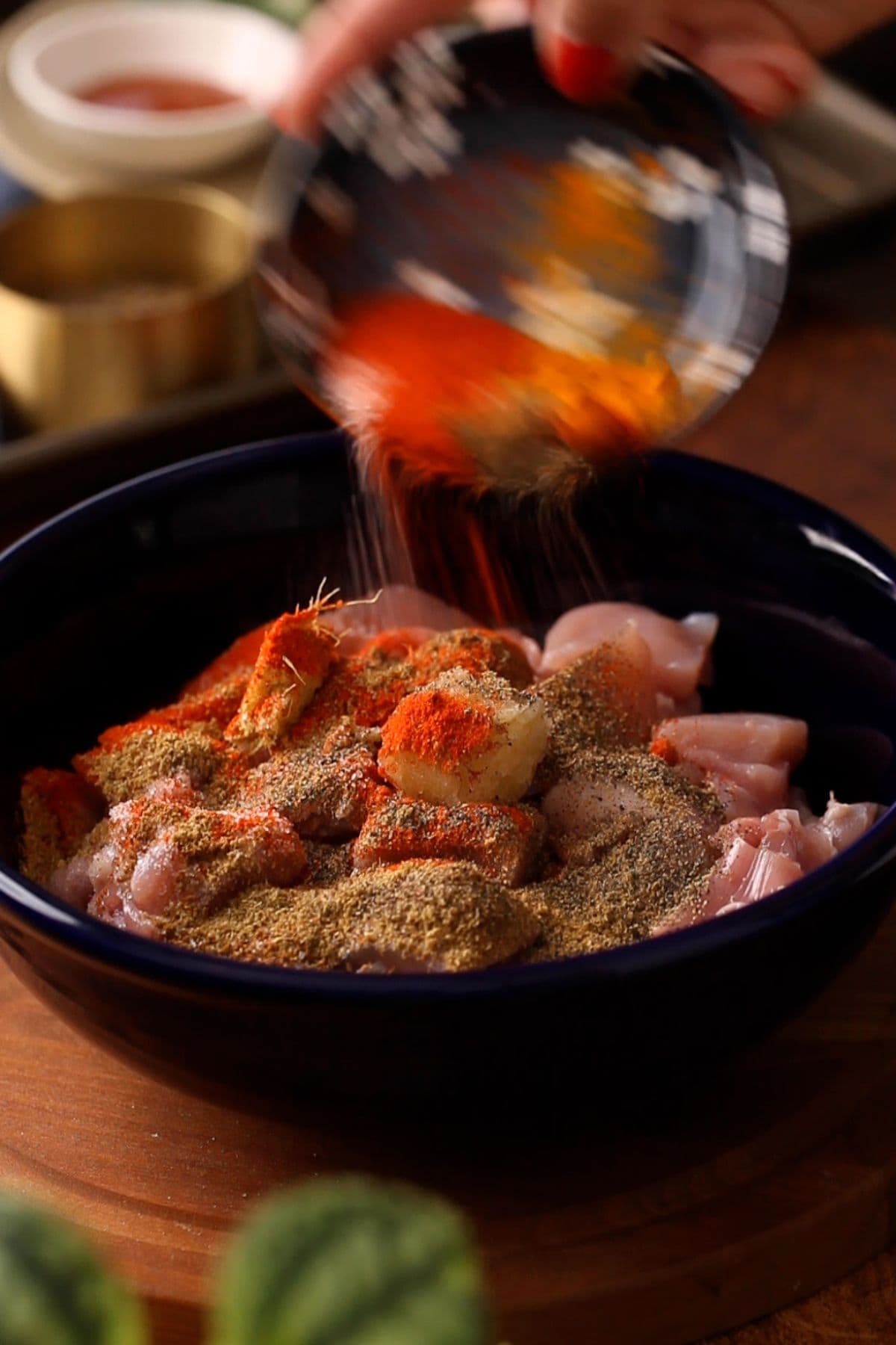 Ground spices are added to the chicken.