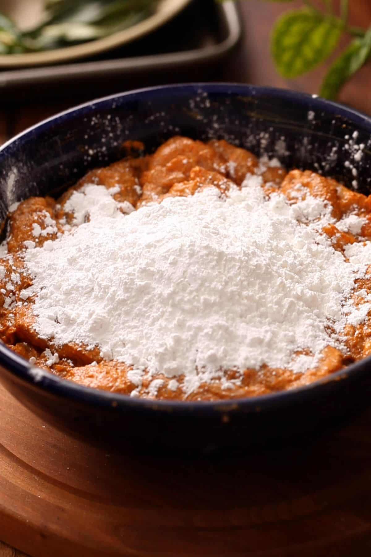 Rice flour and cornstarch is added to the marinated chicken.