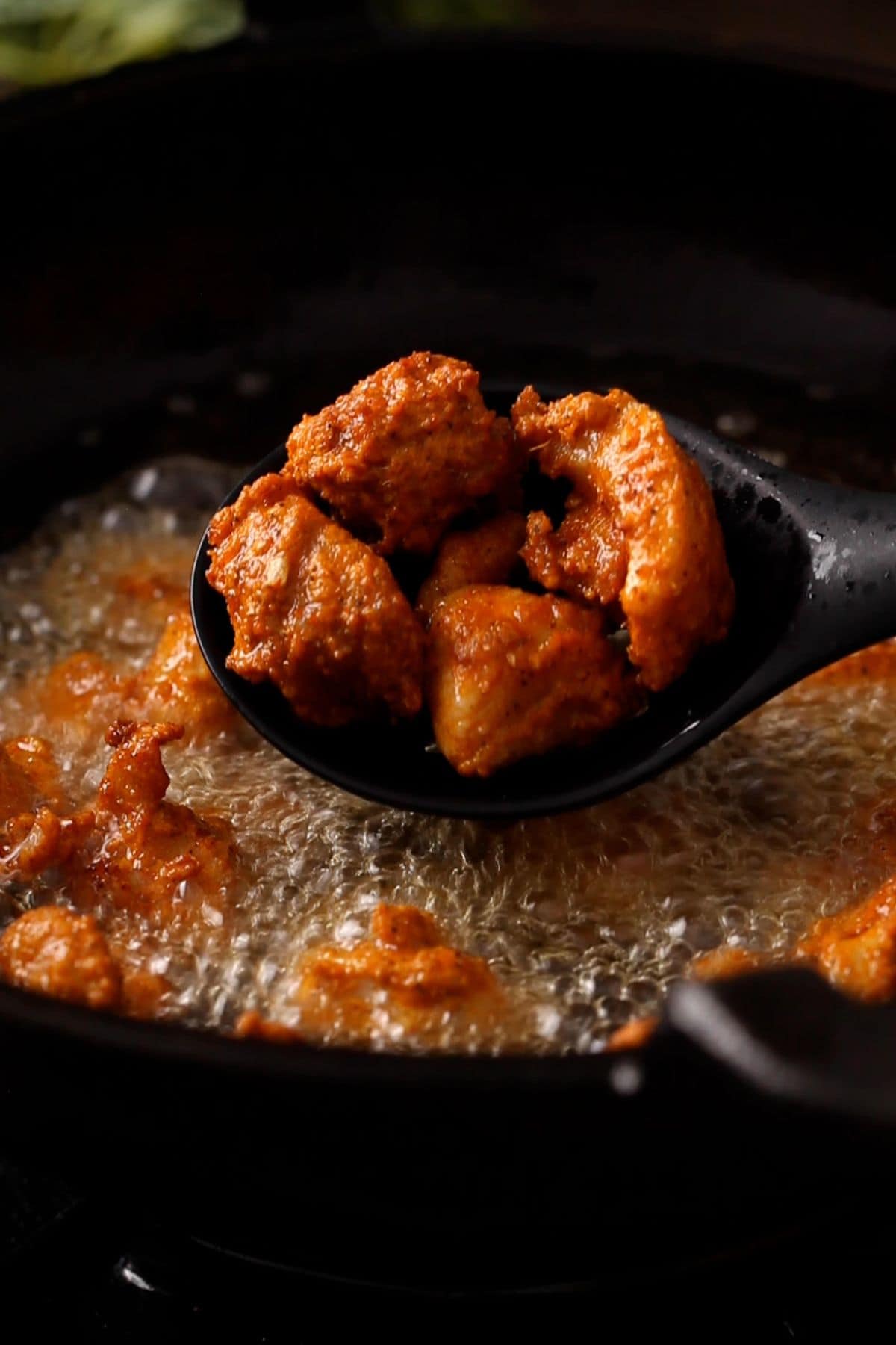 Frying chicken in batches in a cast iron pot.