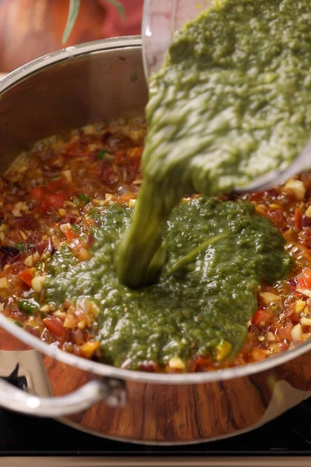 Mashed saag is added to the onion tomato tadka.