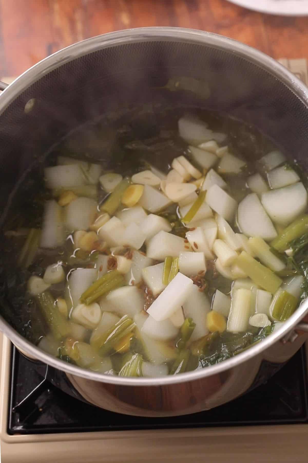 Boiled vegetables and greens for making indian style mustard greens.