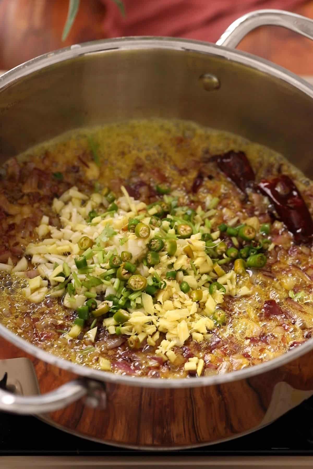 Chopped aromatics are added to the golden browned onions.