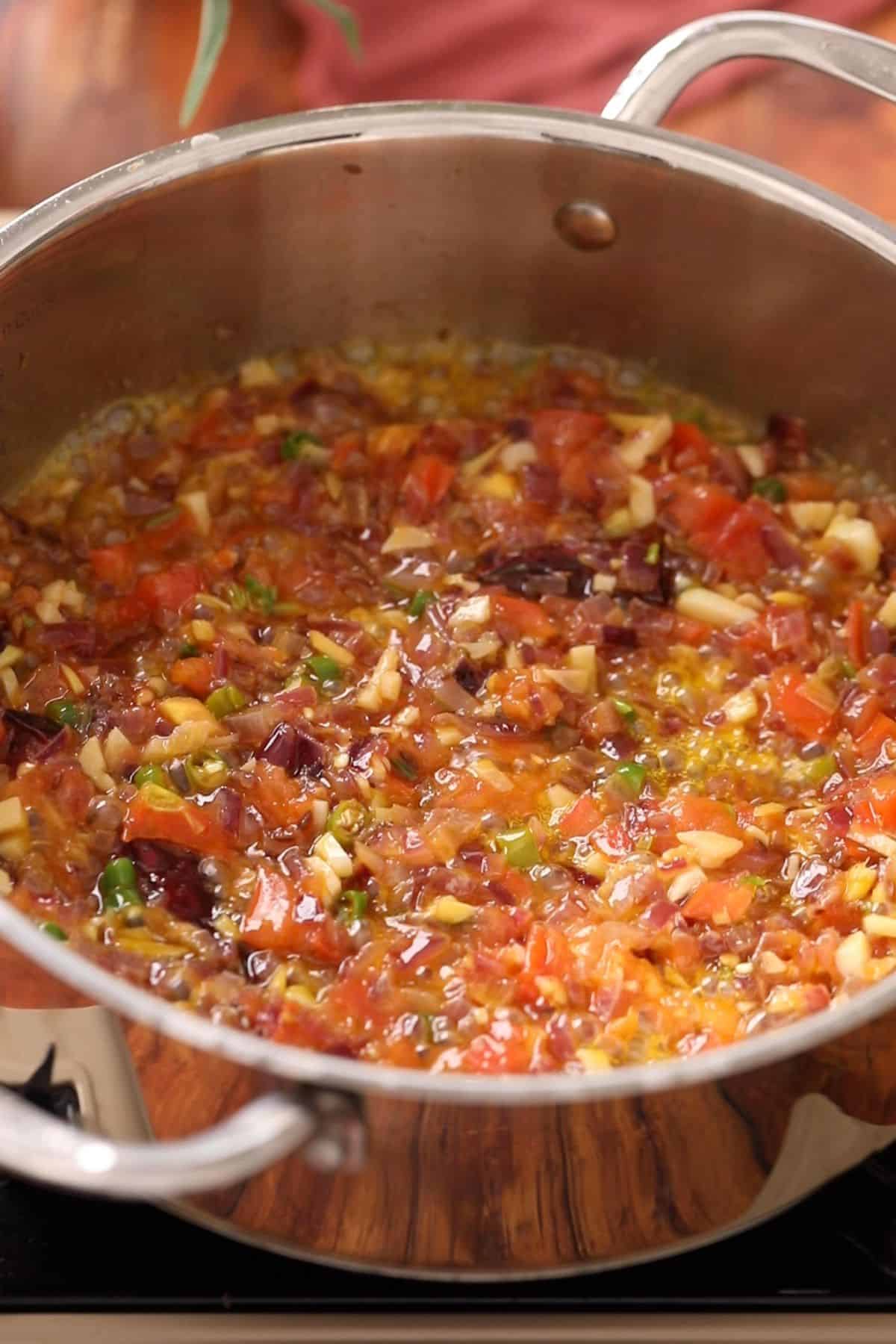 Tomatoes are added to the tempering and cooked until chunky.