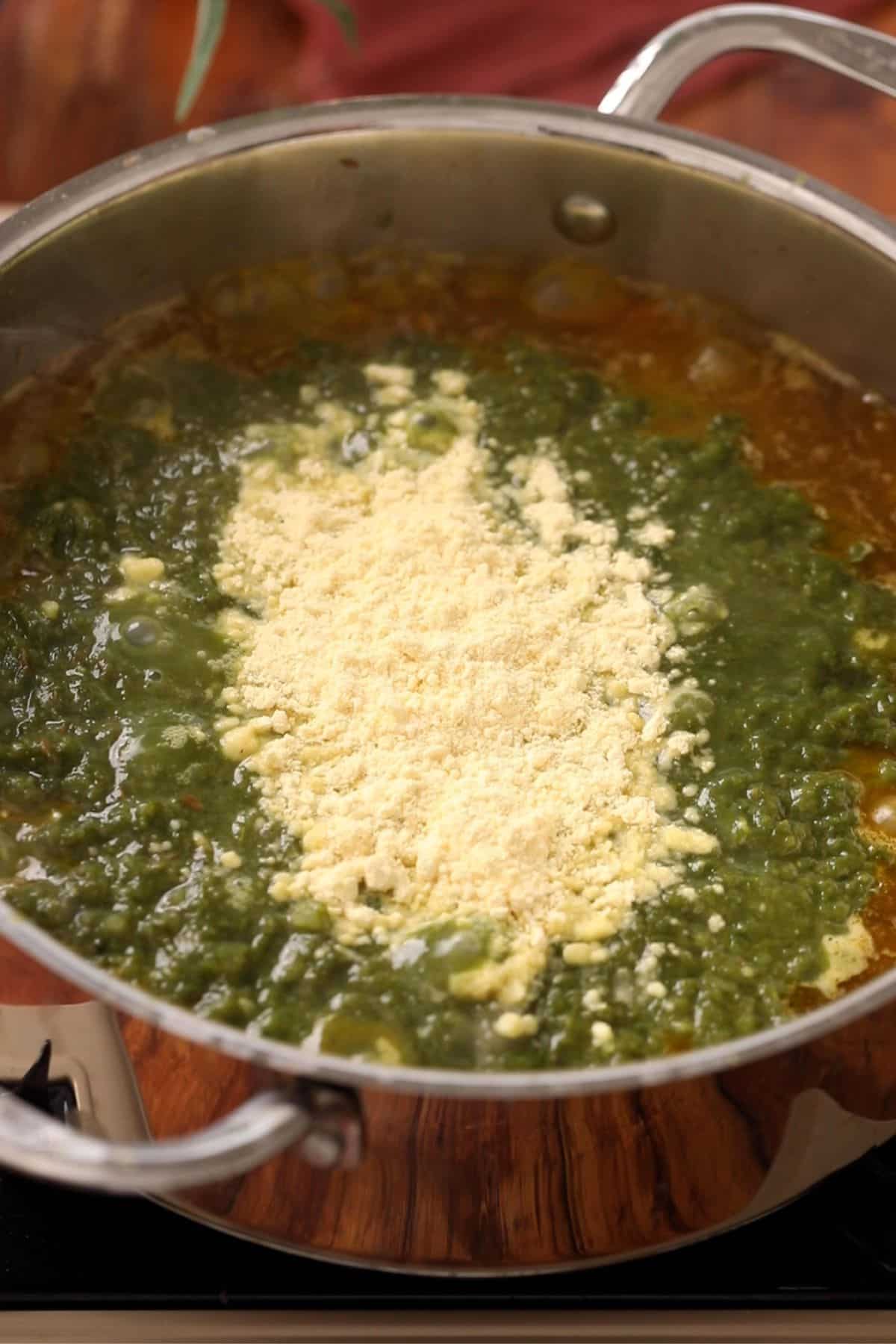 Dry roasted makki atta is added to the saag.