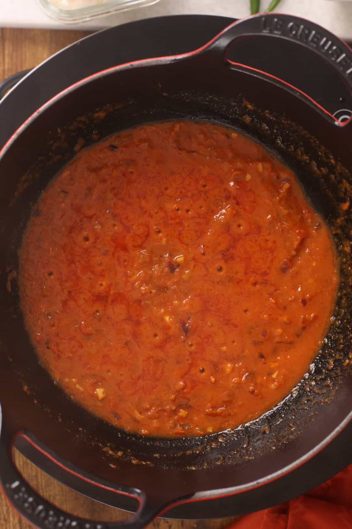 Tiny oil bubbles are seen on top of onion tomato masala.