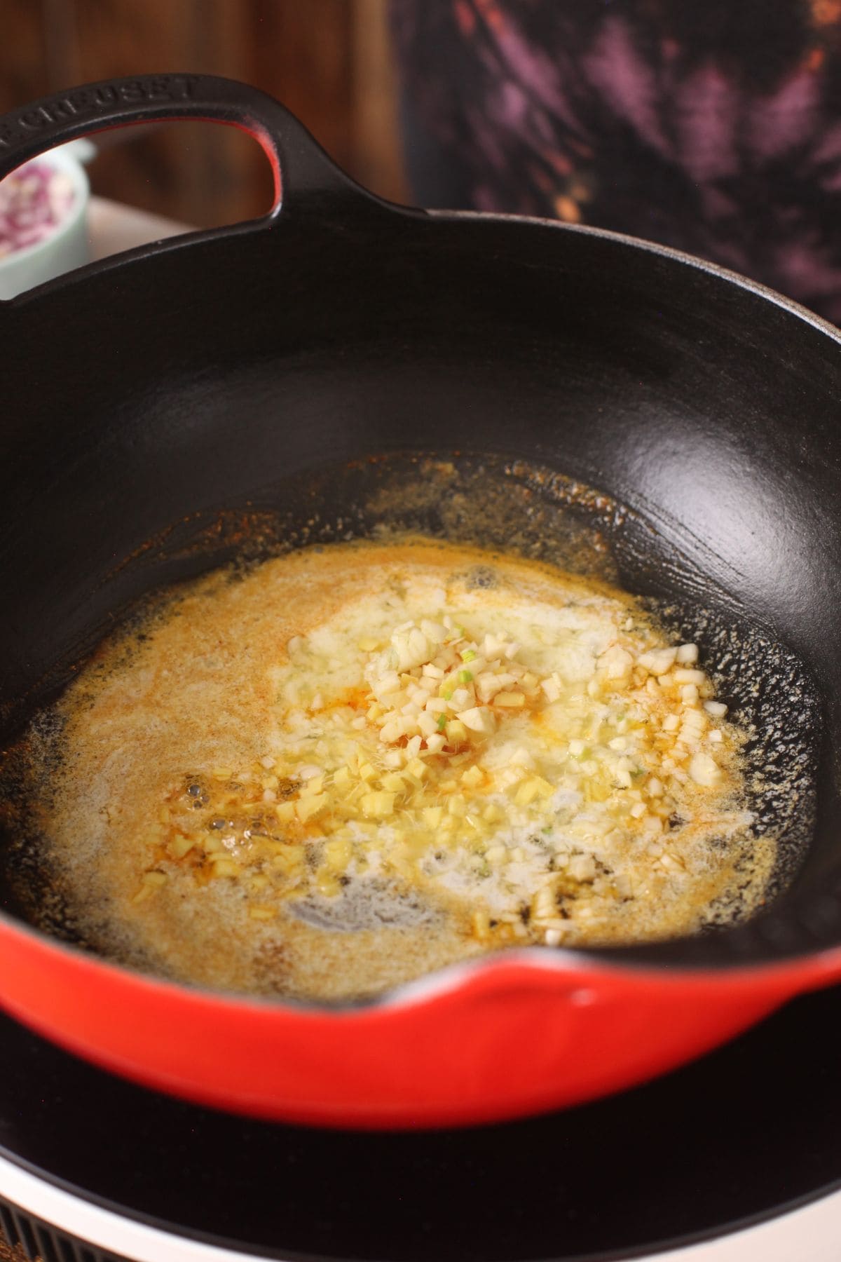 Chopped ginger, garlic and cumin seeds are added to melted butter.