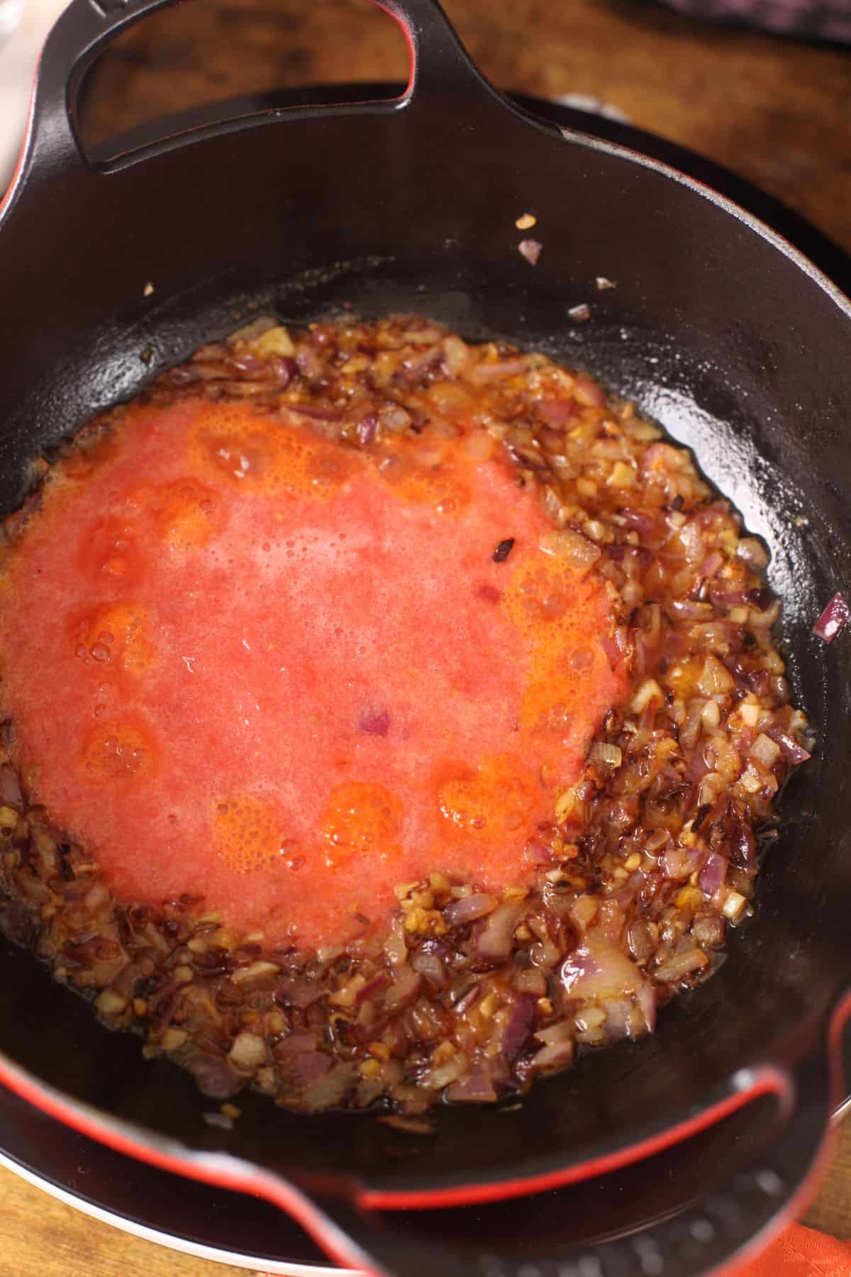 Tomatoes are added to the browned onions.