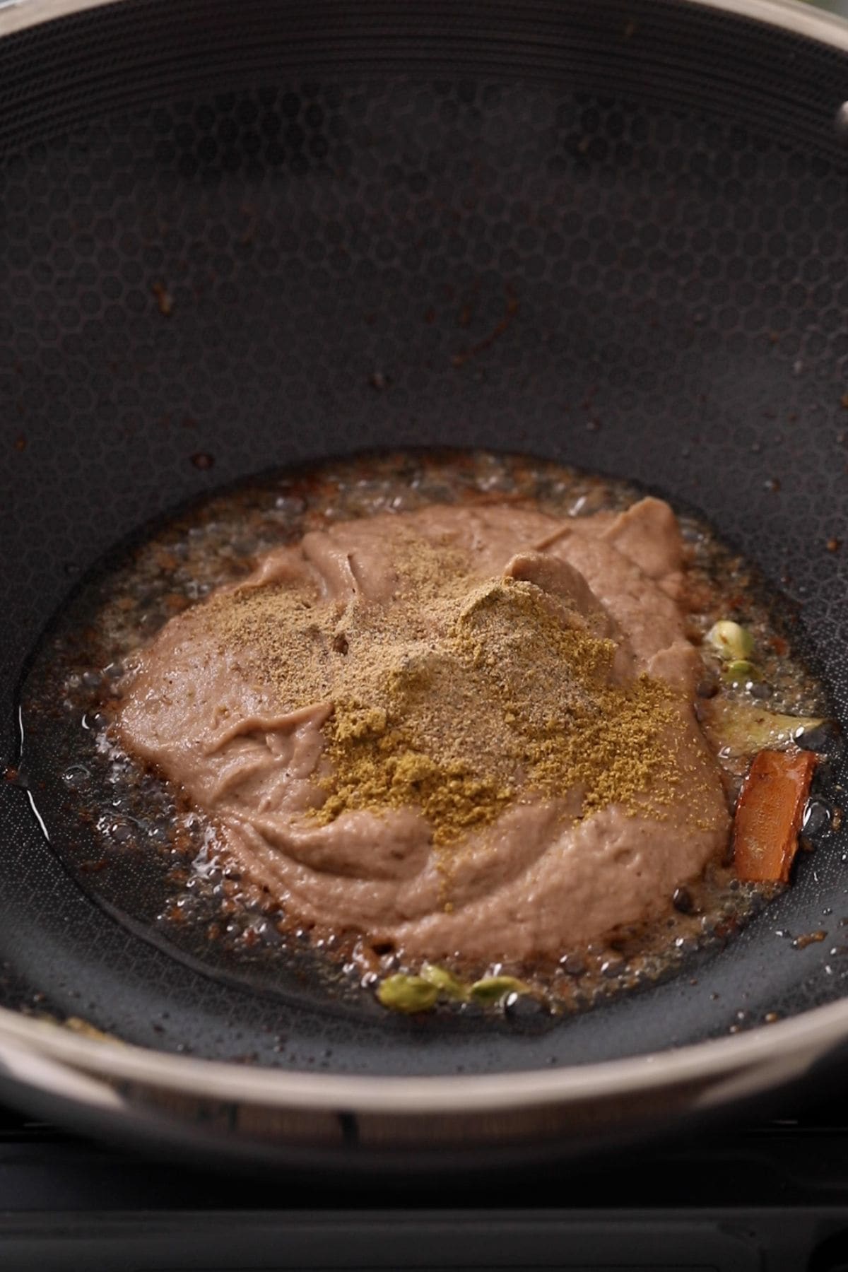 Onion paste, whole spices & ground spices in hot oil.