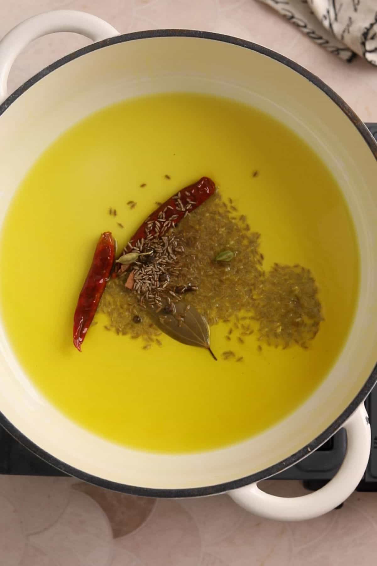 Hot oil is tempered with whole spices.