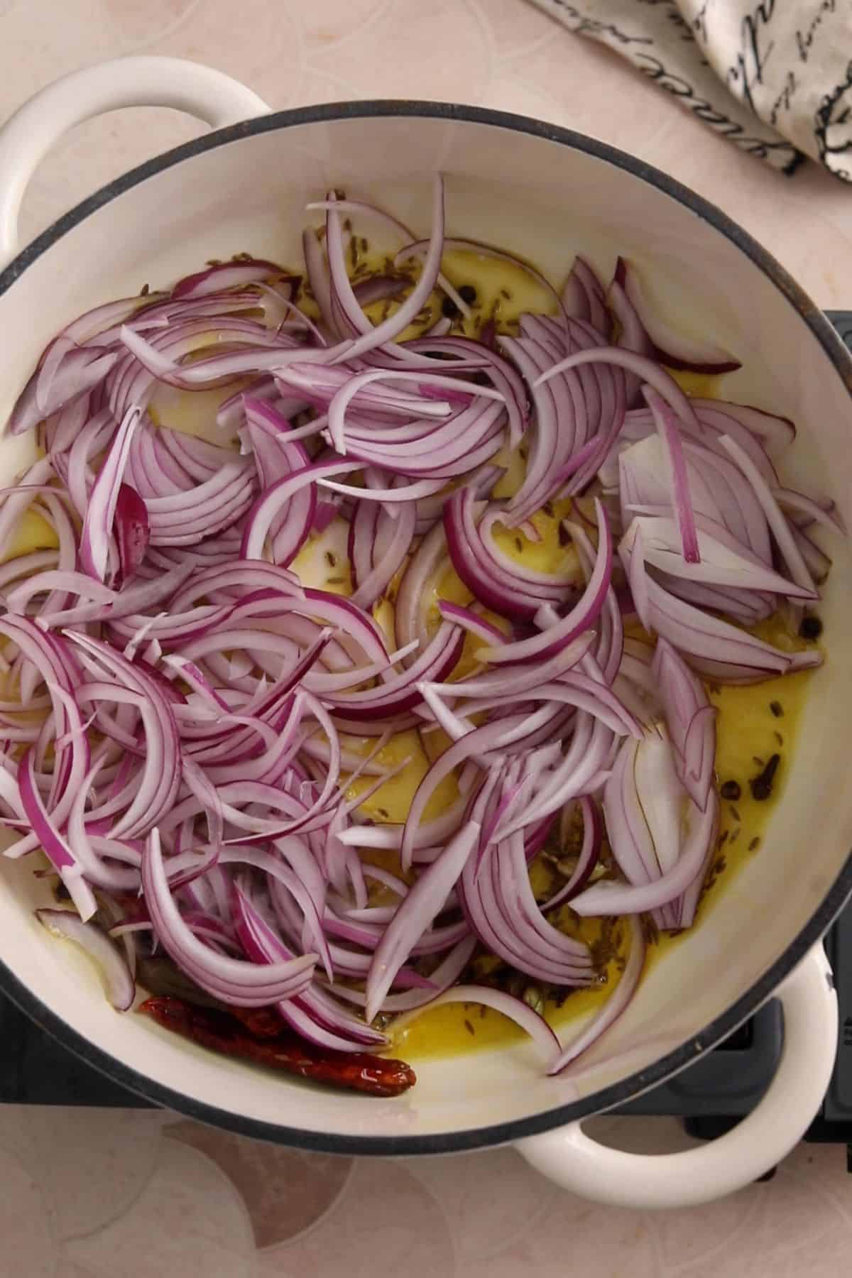 Sliced onions are added to hot oil.