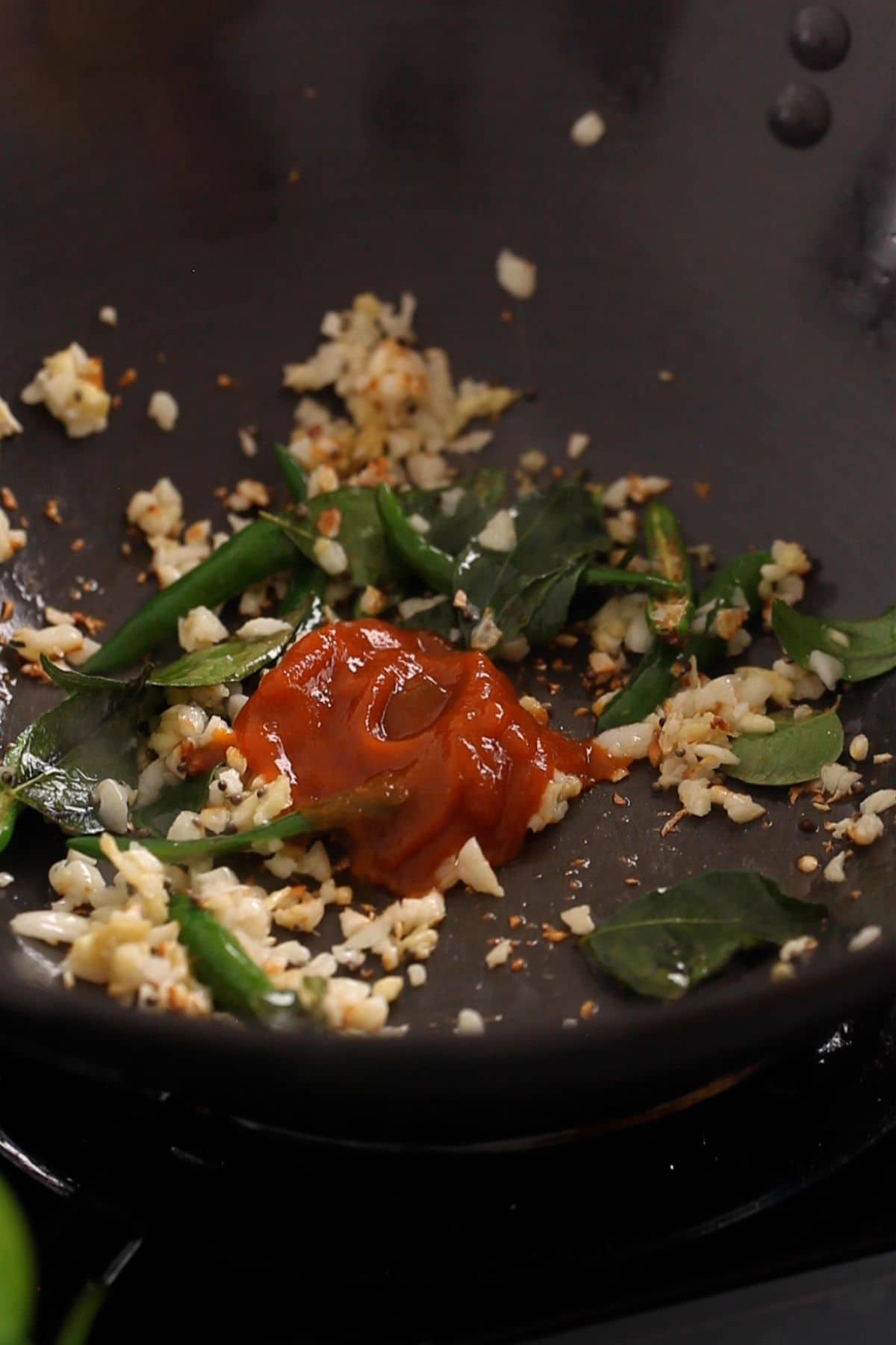Sriracha and ketchup is added to the wok.