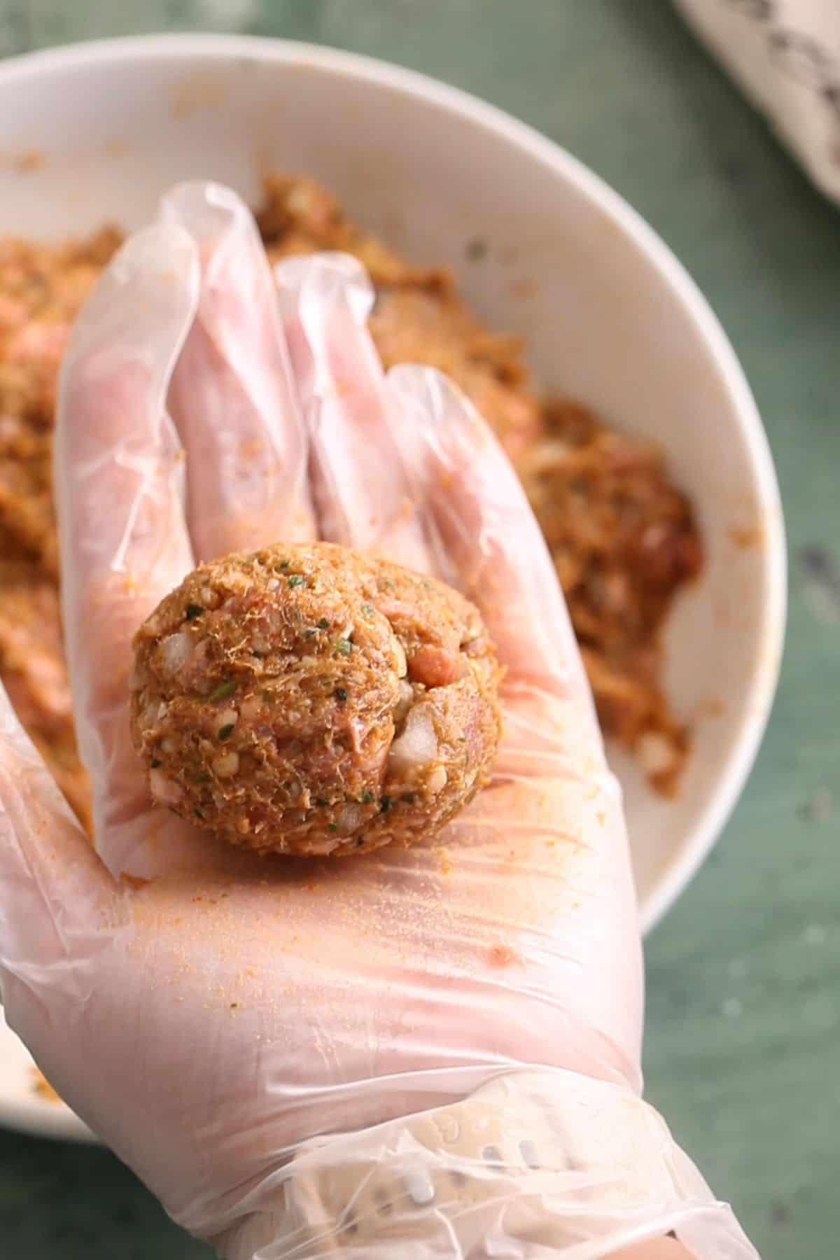 Scooped portion of lamb kebab mixture in palm of hand.