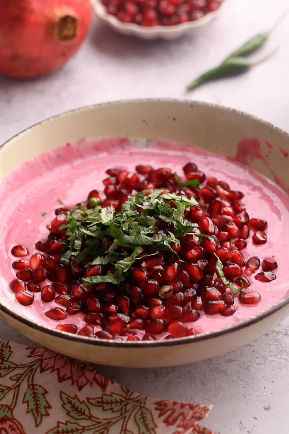 Pomegranate, green chileis and cilantro are added to spiced yogurt.