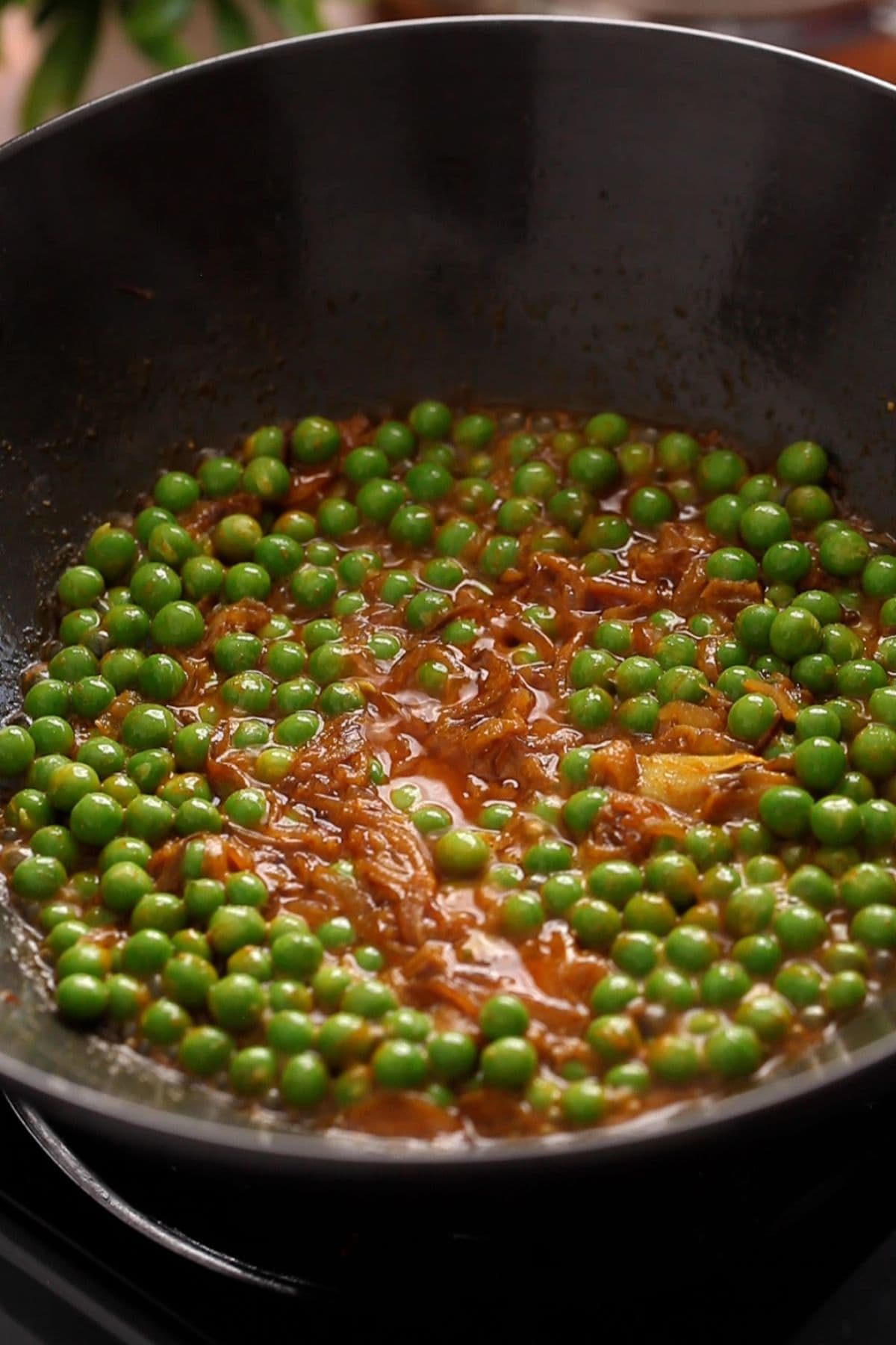 Green peas are cooking in onion masala.