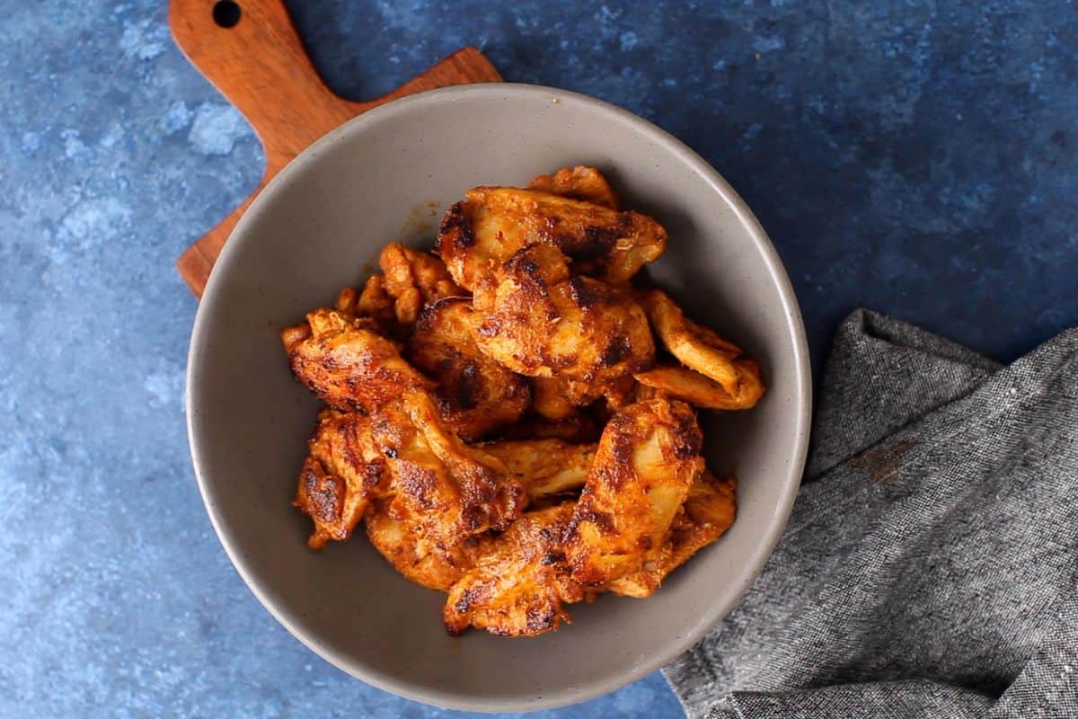 Tandoori chicken tikka in a grey bowl.