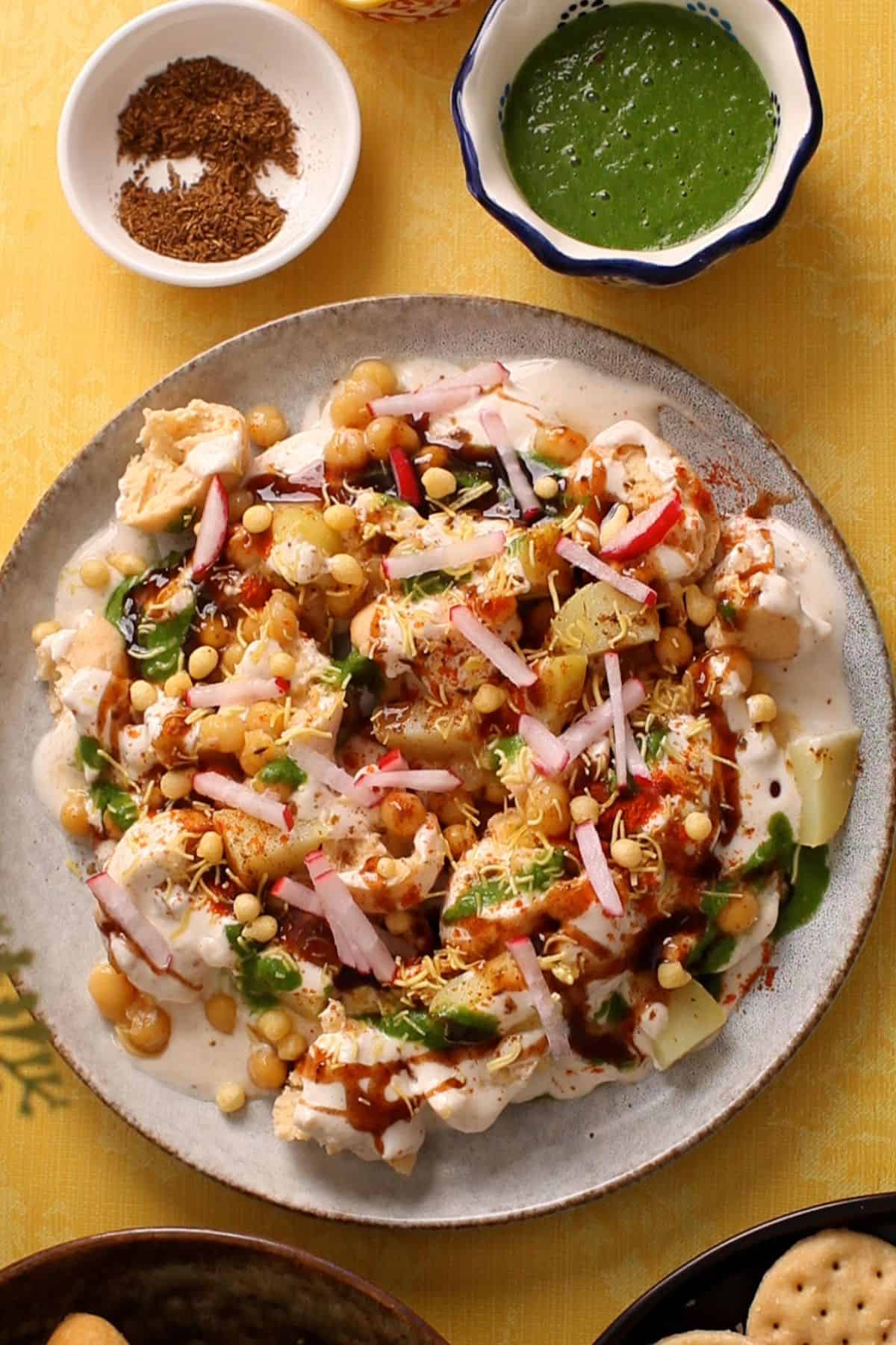 Chutneys, chatt spices and crunchy toppings are added to bhall papdi chaat.