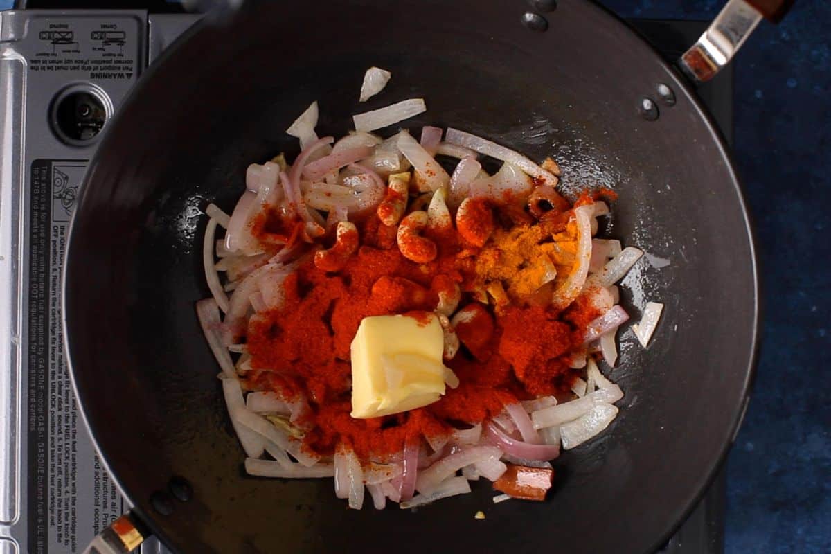Ginger, garlic, spices, butter and raw cashews are added to the onions.