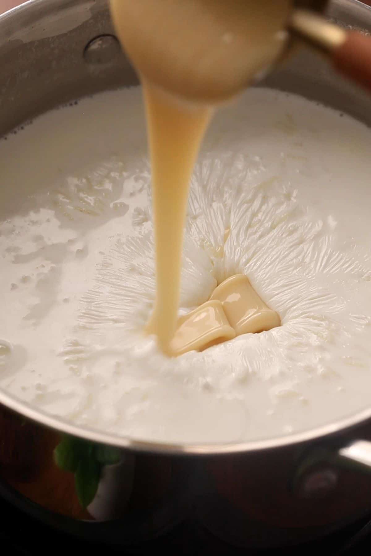 Adding condensed milk to kheer.