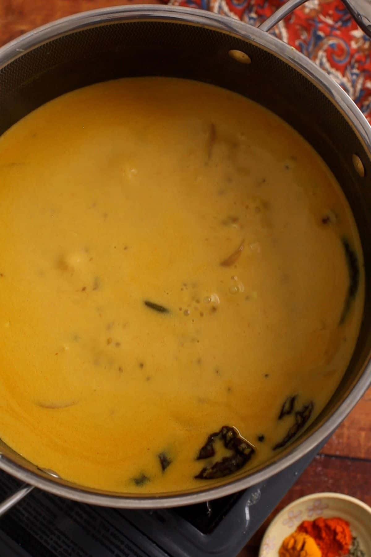 After first boil, kadhi is left to slow cook and simmer.