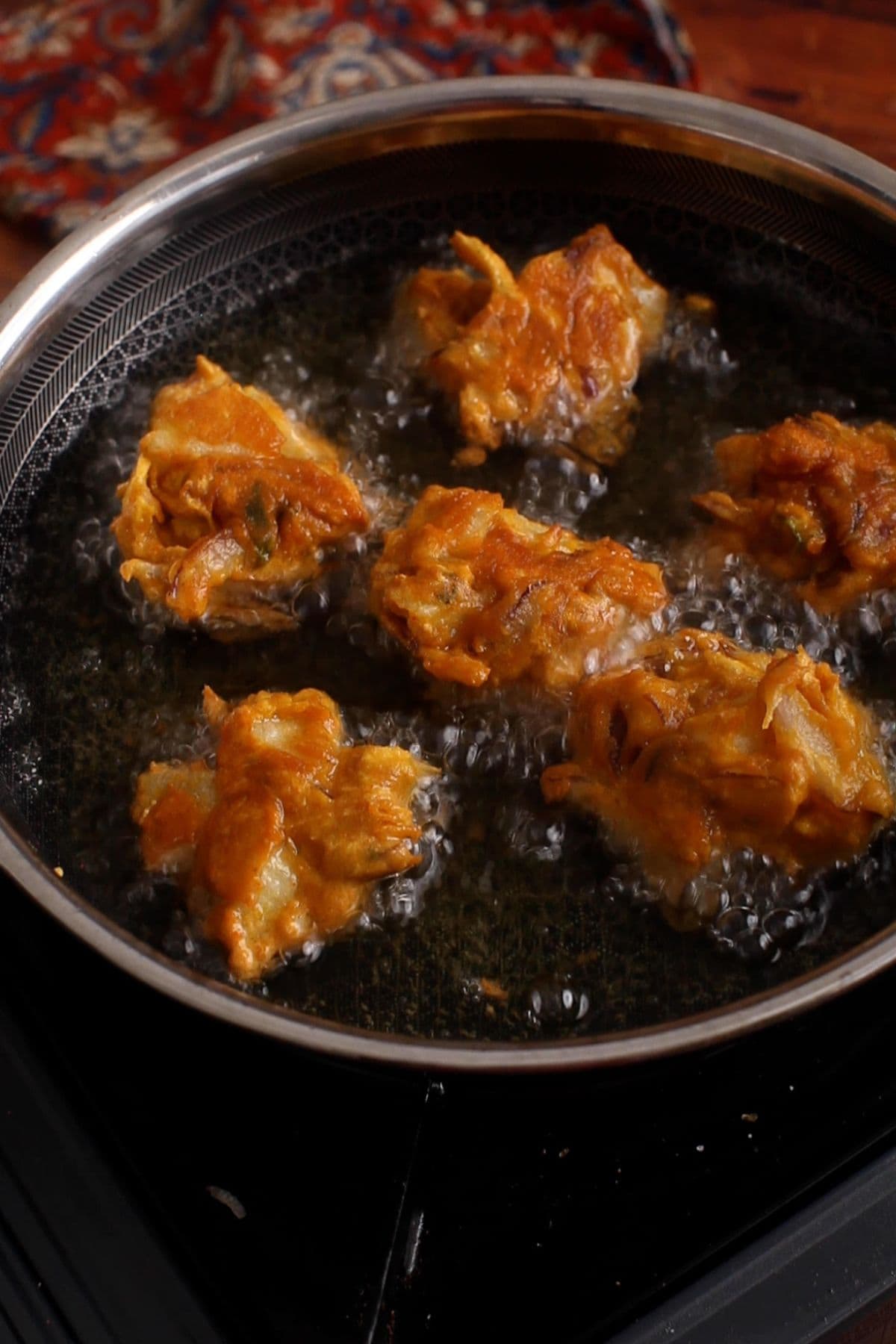 Golden fried pakoras for kadhi in hot oil.