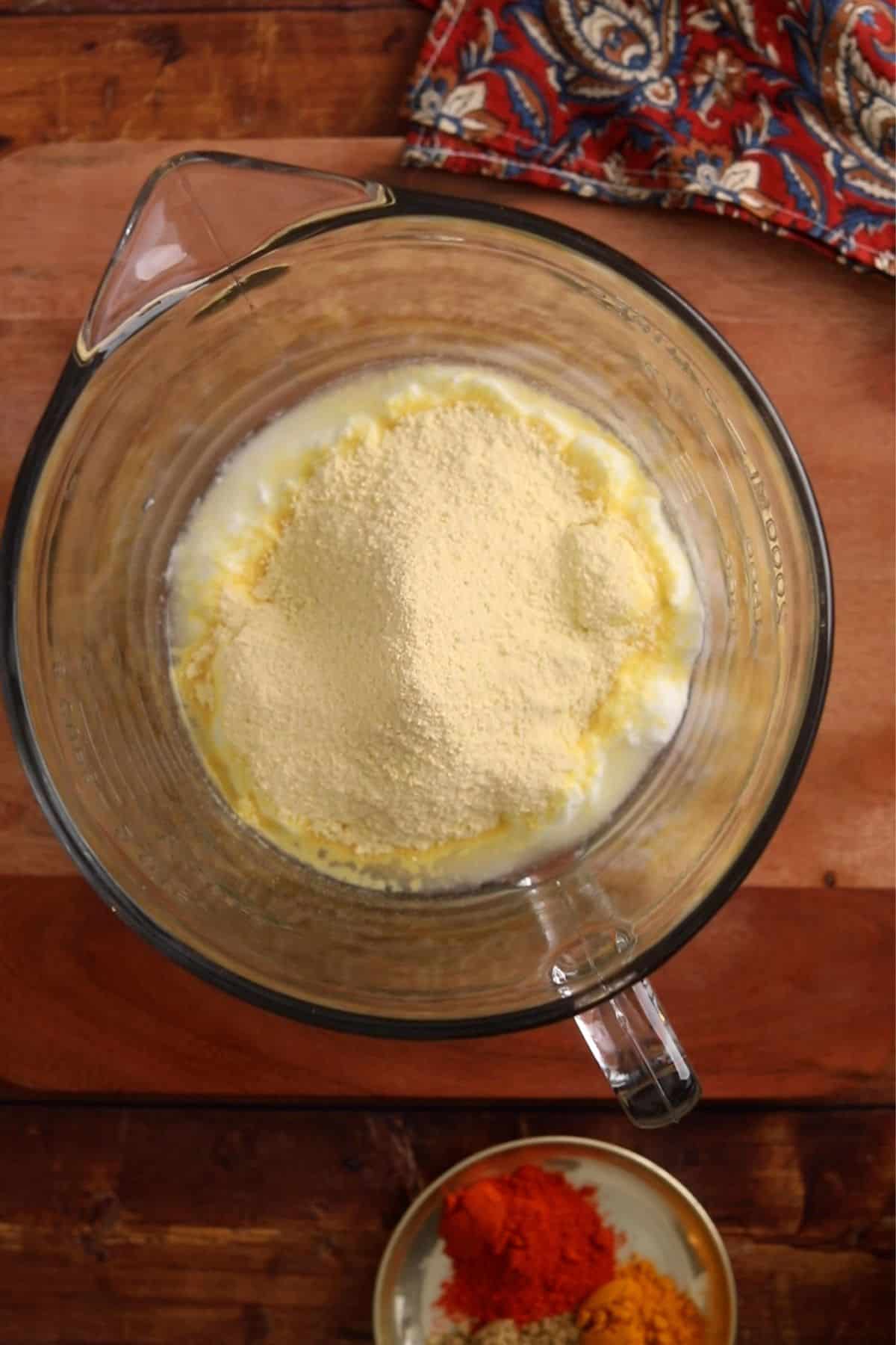 Lump free besan sieved over yogurt.